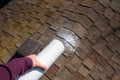 WomanÃ¢â¬â¢s hand shaking moss killer granules on the ridgeline of a house with asphalt shingle roof